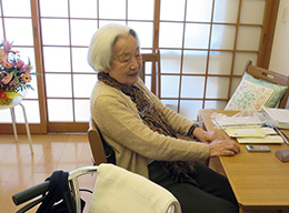 部屋でくつろぐ山下外子さんの写真